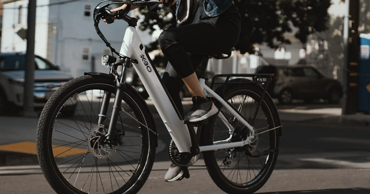Biciclist pe o pistă, pe fundal urban, lumină de zi