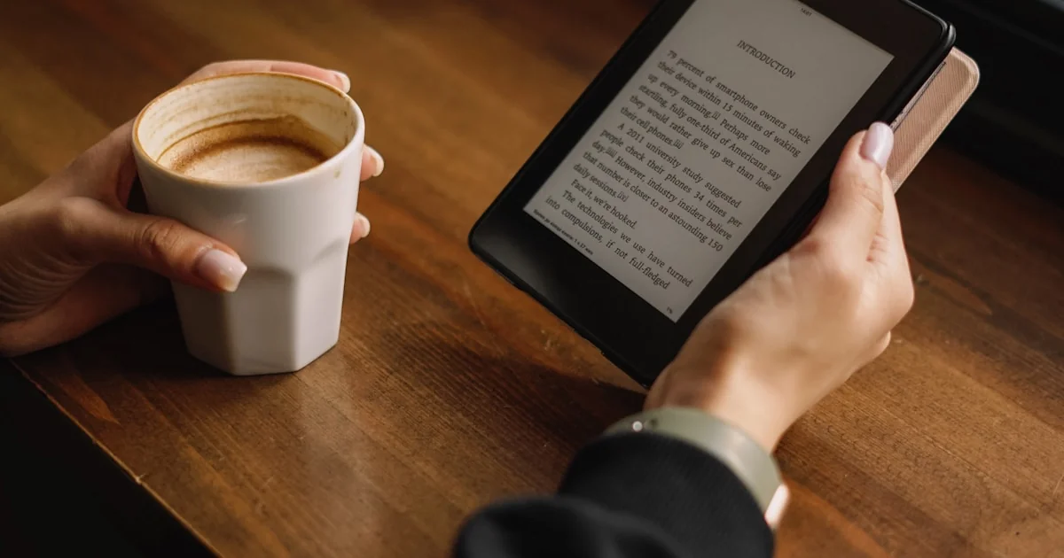 Cititor ebook pe masă, ecran e-ink lângă o cafea