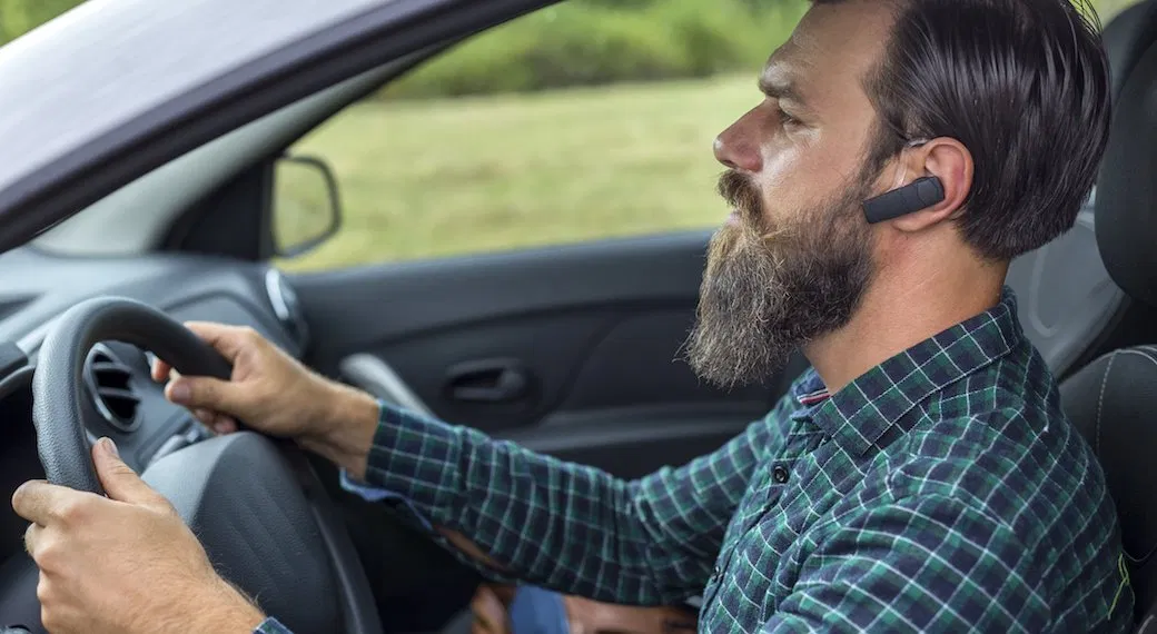 Șofer cu mâinile pe volan — apel handsfree în mașină