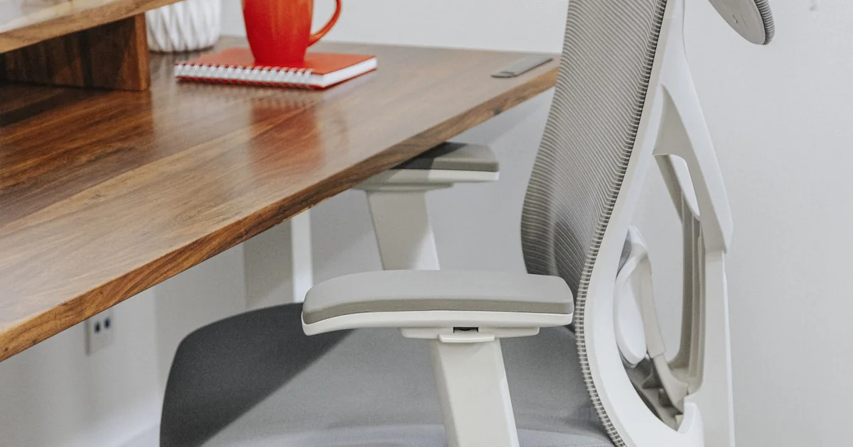 Scaun de birou ergonomic negru lângă birou minimalist