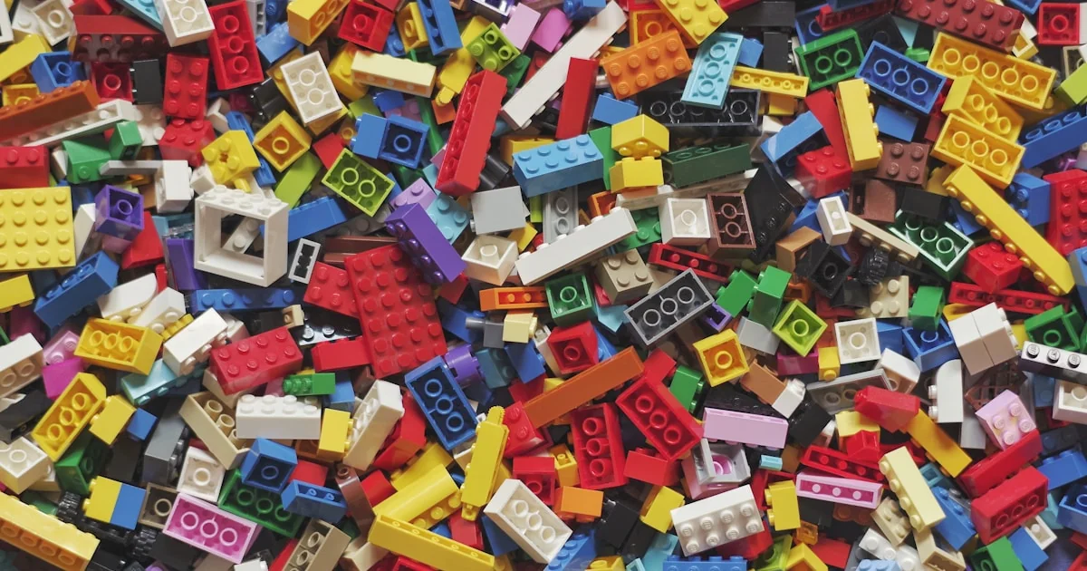 Piese LEGO colorate aranjate pe o suprafață luminoasă